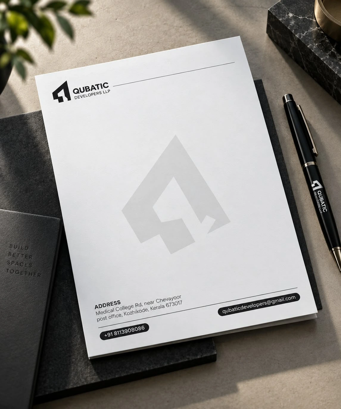 Qubatic Developers LLP letterhead with branded pen and notebook
